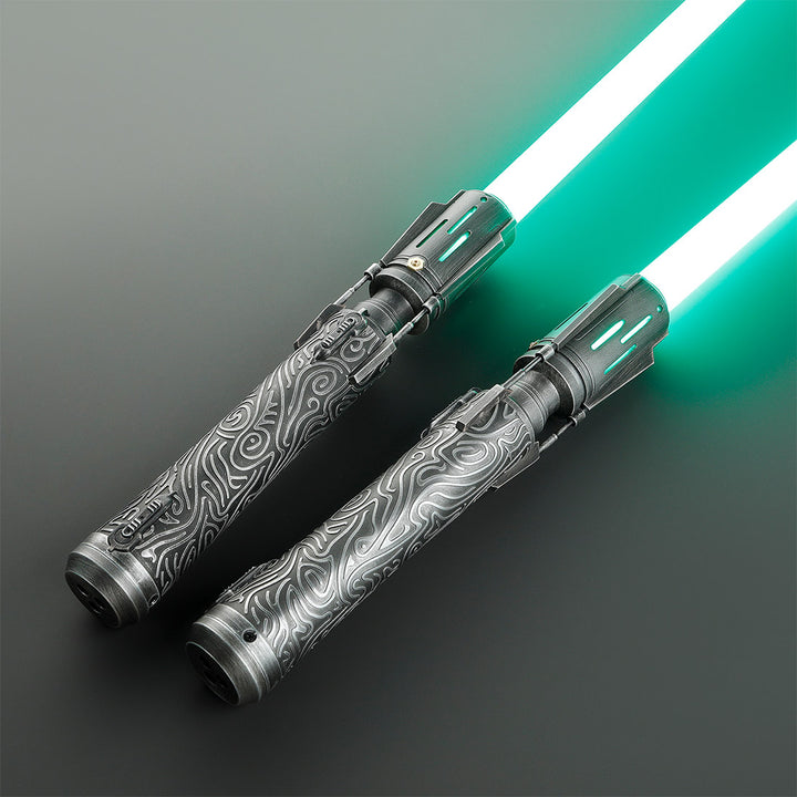 Two decorative double-bladed lightsabers with glowing green blades and detailed silver-gray patterned handles, displayed diagonally on a dark gray background.